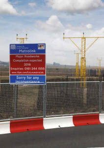 Sign for Manchester Metrolink behind MASS Barrier and perimeter fencing